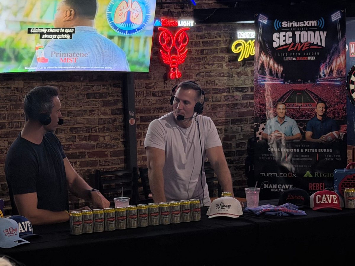 Hosts Chris Doering and Peter Burns broadcasting live in front of the SEC Today Live banner